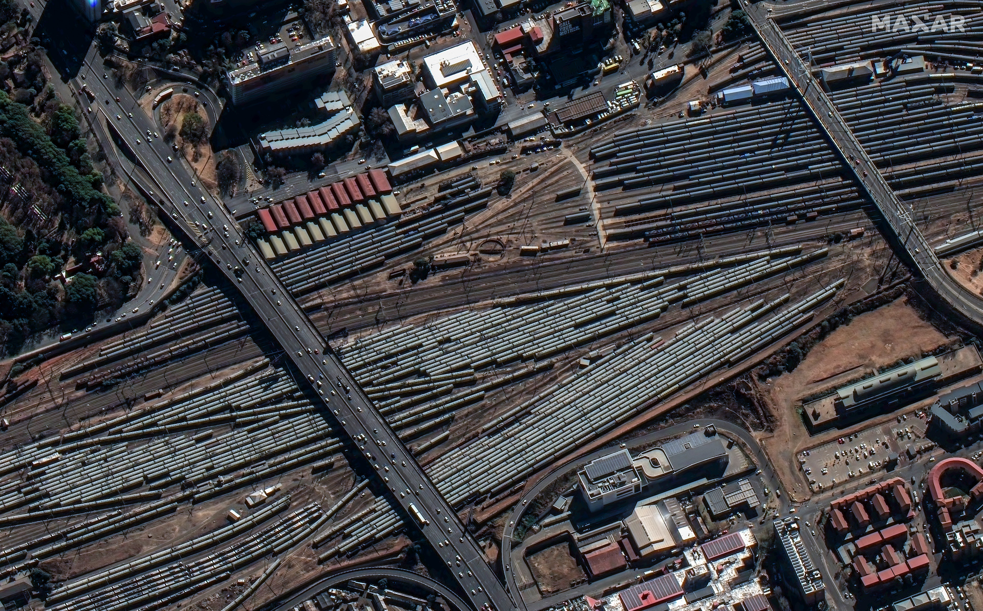 WorldView Legion collected an image of Johannesburg, South Africa, showing the Nelson Mandela Bridge (right) and De Villiers Graaff Motorway (left) spanning the large railyard adjacent to Johannesburg Park Station, a main train terminal in the city. Individual rail lines and overhead line equipment, as well as dozens of rail cars, can be seen in this image.