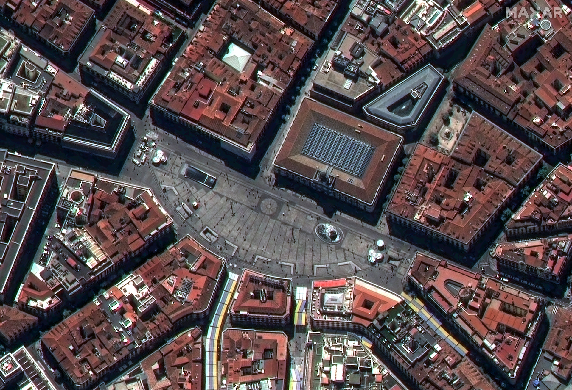 This busy plaza in Madrid, Spain, is called Puerta del Sol, or Gate of the Sun, and it is home to the marker for the beginning of the radial road network in Spain as well as two famous statues. In this WorldView Legion image, the streets across the bottom of the image have colorful fabric strung between the buildings to provide shade for the pedestrians. 