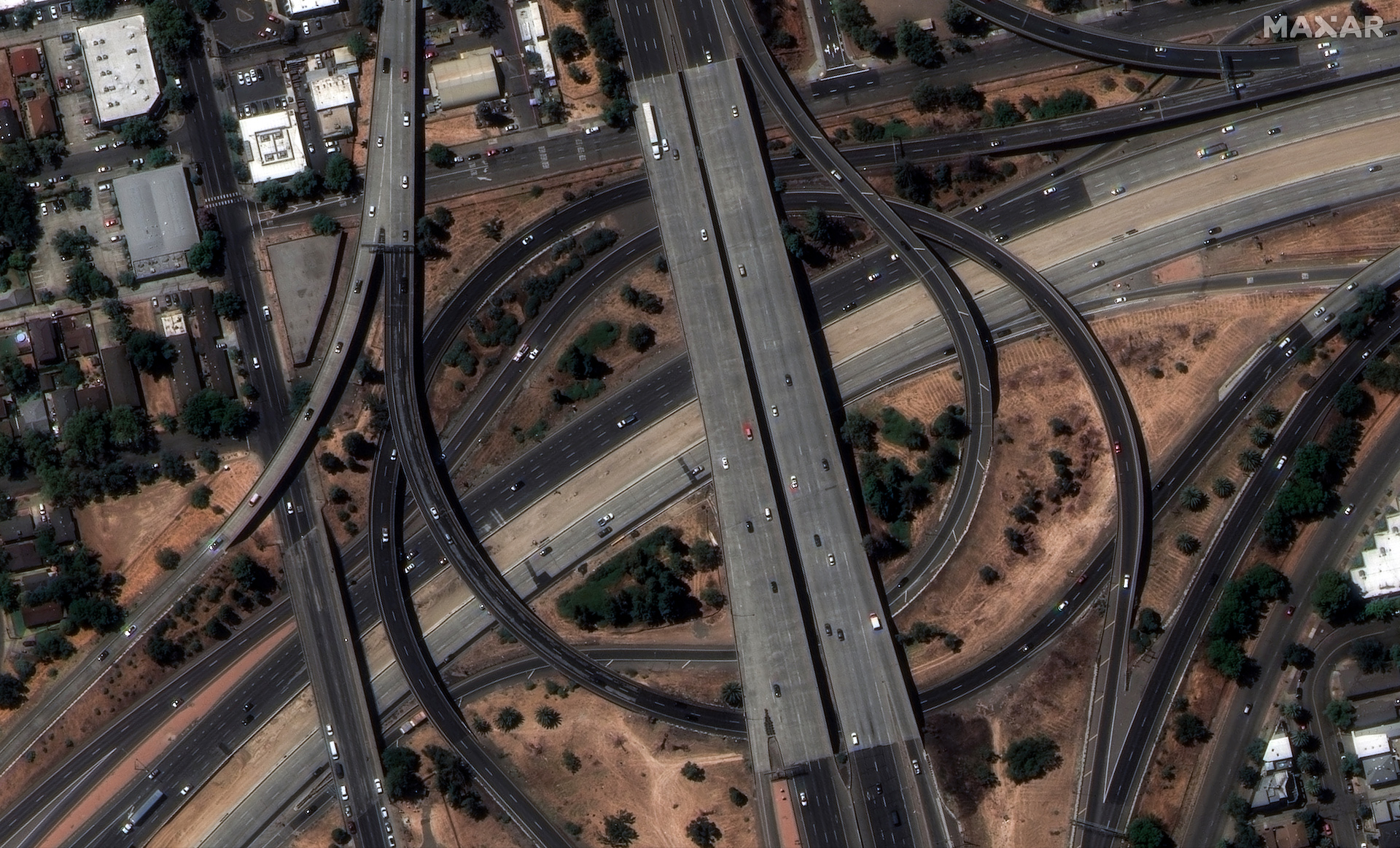 This WorldView Legion image shows the interchange between Highway 50 and Elvas Freeway, southeast of downtown Sacramento, with vehicles in motion and roadway markings clearly visible.